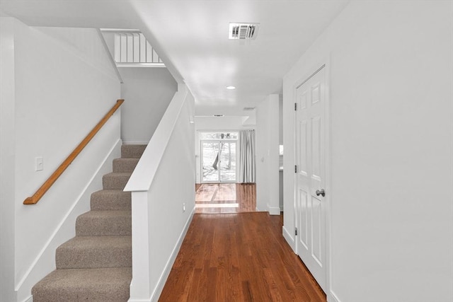 foyer with baseboards, stairs, visible vents, and wood finished floors