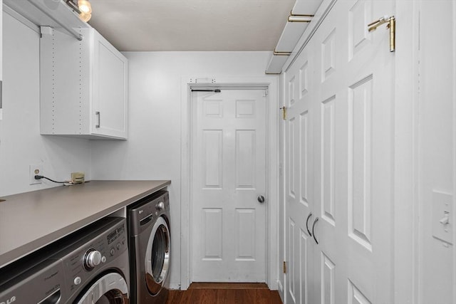 laundry area featuring dark wood-style flooring, cabinet space, and washer and clothes dryer