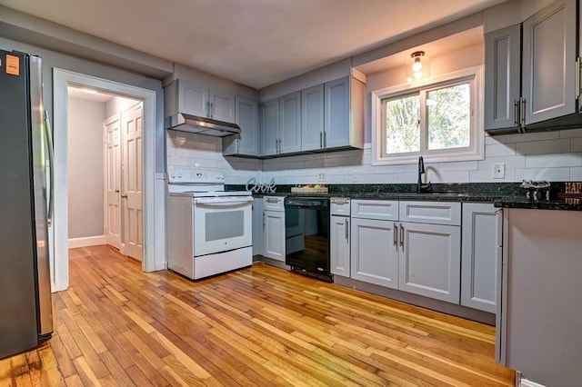 kitchen with white range with electric cooktop, dishwasher, stainless steel refrigerator, and tasteful backsplash