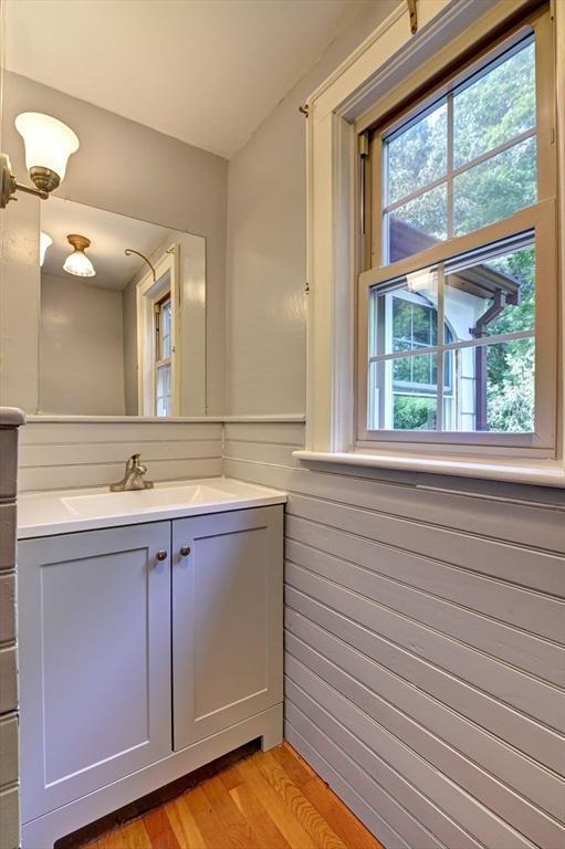 bathroom featuring vanity, wood-type flooring, and wooden walls