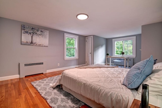 bedroom with hardwood / wood-style flooring and radiator