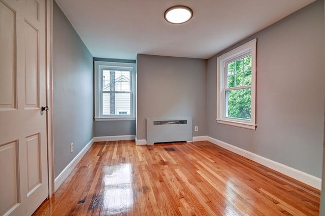 spare room with radiator and light hardwood / wood-style flooring