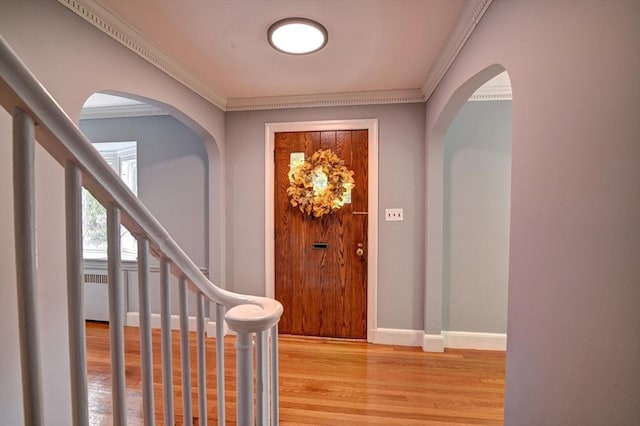 entryway with light hardwood / wood-style flooring and ornamental molding