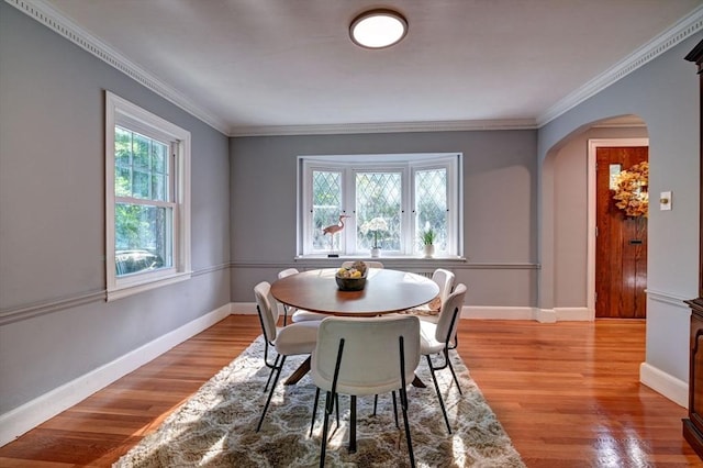 dining area with crown molding and light hardwood / wood-style flooring