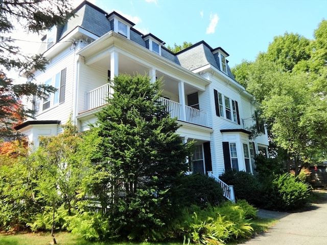 view of side of property featuring mansard roof