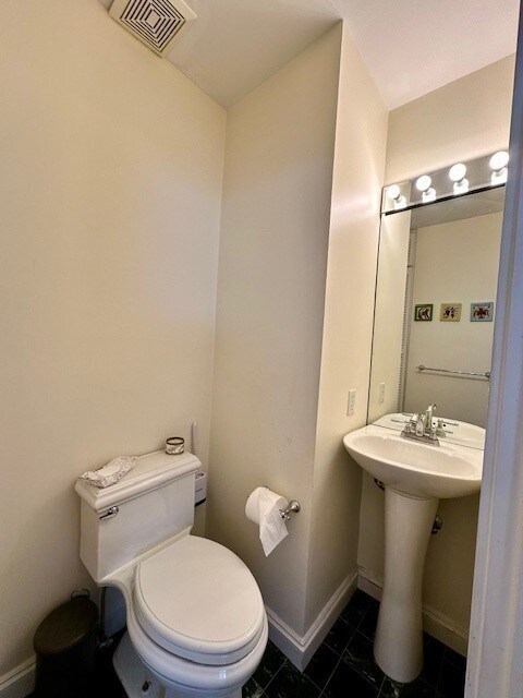 bathroom featuring tile patterned floors, toilet, baseboards, and visible vents