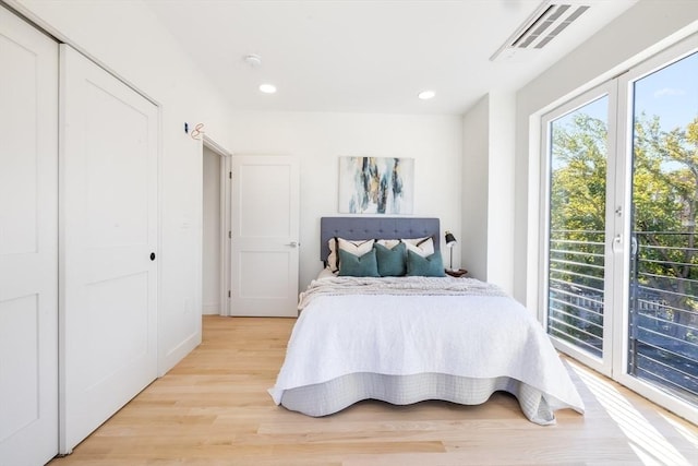 bedroom featuring access to outside, a closet, and light hardwood / wood-style flooring