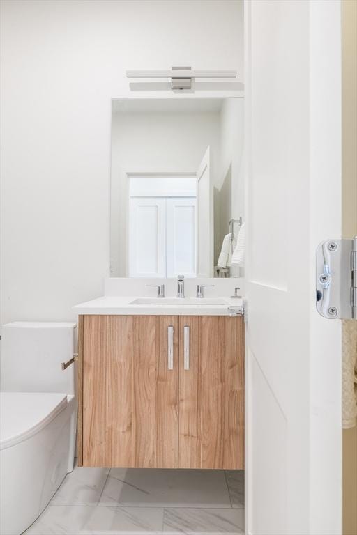 bathroom featuring tile patterned flooring, vanity, and toilet