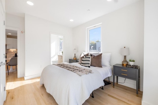 bedroom featuring connected bathroom and wood-type flooring