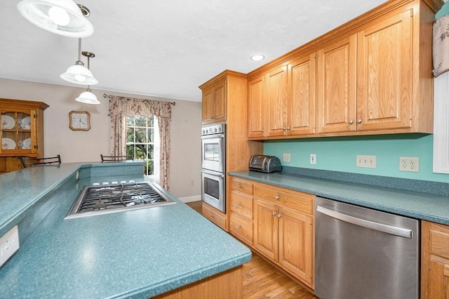 kitchen with stainless steel appliances, decorative light fixtures, recessed lighting, and light wood finished floors