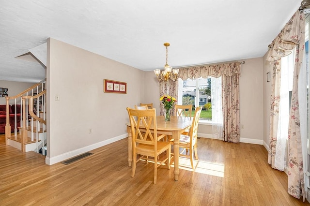 dining room with visible vents, an inviting chandelier, stairs, baseboards, and light wood-type flooring