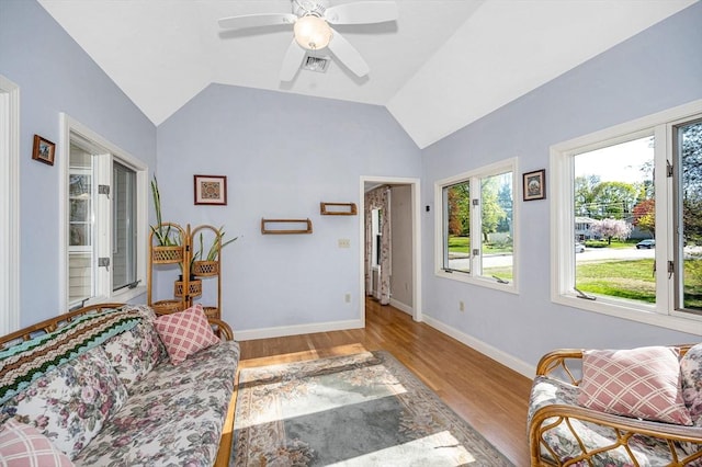 living room featuring visible vents, vaulted ceiling, wood finished floors, and a wealth of natural light