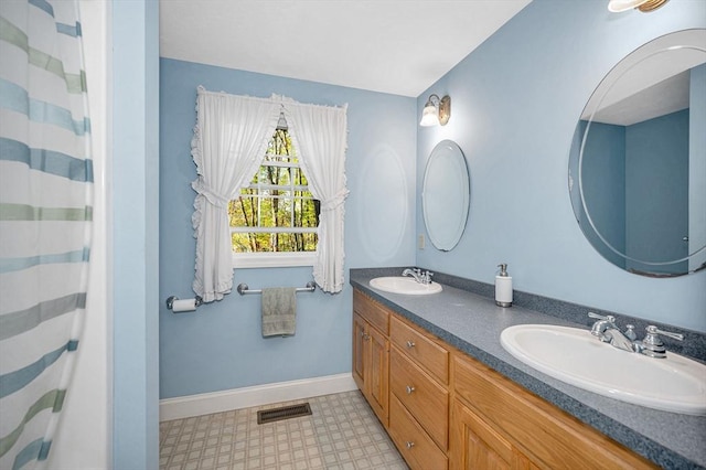 full bathroom with double vanity, tile patterned floors, visible vents, and a sink
