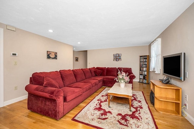 living room featuring recessed lighting, baseboards, and light wood-type flooring