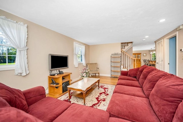 living room with recessed lighting, baseboards, stairs, and wood finished floors