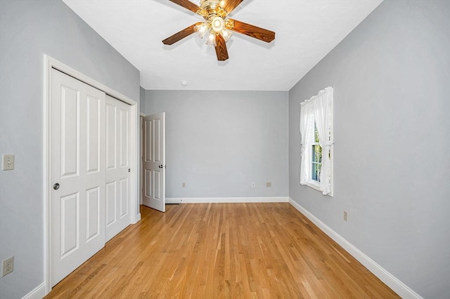 unfurnished bedroom with baseboards, a ceiling fan, a closet, and light wood finished floors