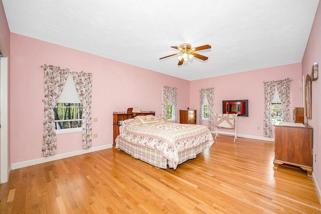 bedroom featuring light wood-type flooring, a ceiling fan, and baseboards