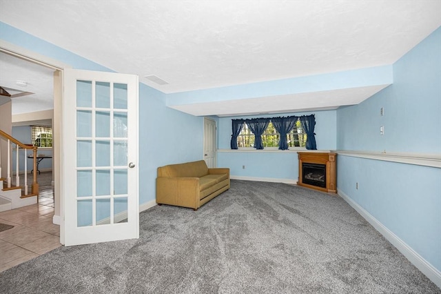 unfurnished room with carpet floors, baseboards, a fireplace, and stairway