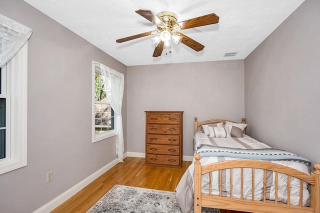 bedroom featuring visible vents, baseboards, ceiling fan, and light wood-type flooring