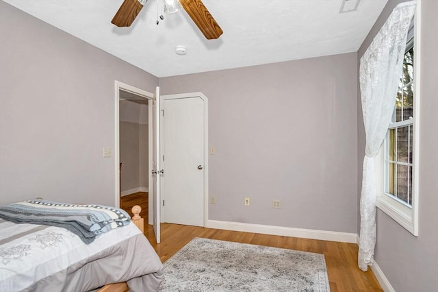 bedroom featuring baseboards, ceiling fan, and wood finished floors