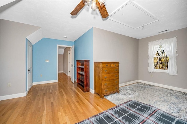 interior space with visible vents, wood finished floors, baseboards, attic access, and a ceiling fan