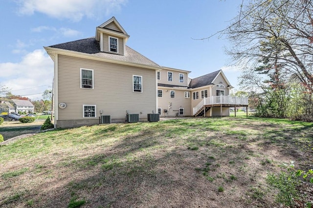 rear view of house featuring stairs, central AC unit, a wooden deck, and a yard