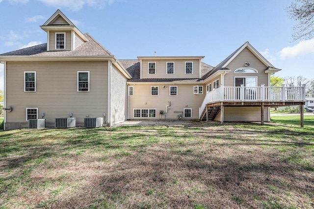 rear view of house featuring roof with shingles, central air condition unit, a deck, stairway, and a lawn