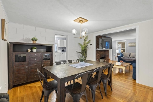 dining space featuring parquet floors, a fireplace, and a notable chandelier