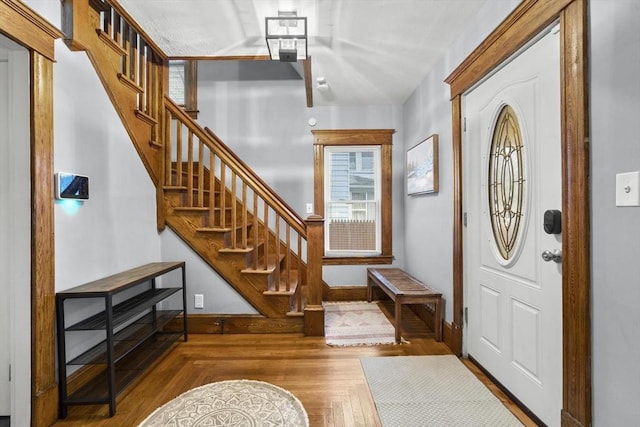 entryway featuring stairway, wood finished floors, and baseboards