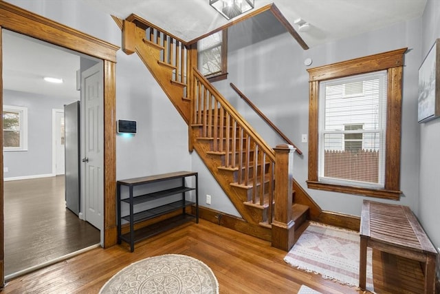 stairs featuring wood finished floors and baseboards