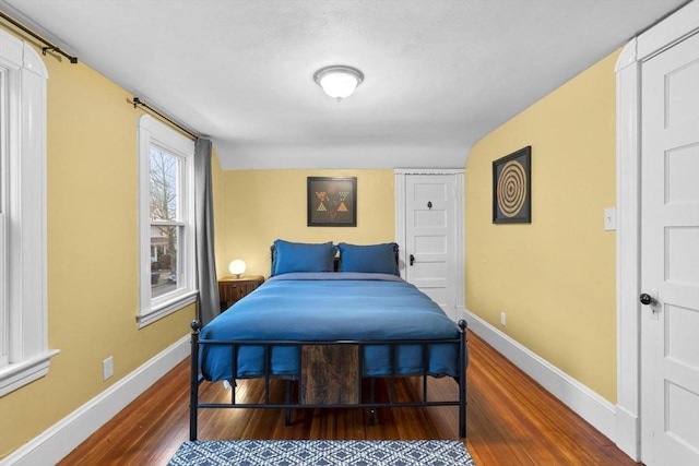 bedroom with baseboards and wood finished floors