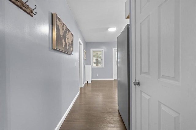 hallway featuring dark wood-type flooring and baseboards