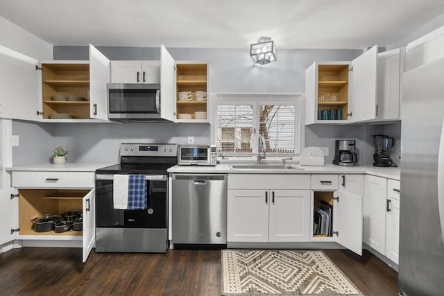 kitchen featuring stainless steel appliances, open shelves, and a sink