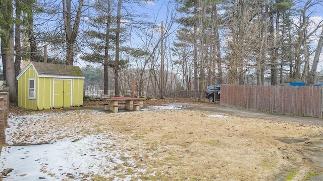 view of yard with an outbuilding, a shed, and fence