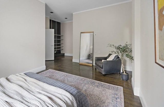 bedroom with crown molding, baseboards, and wood finished floors