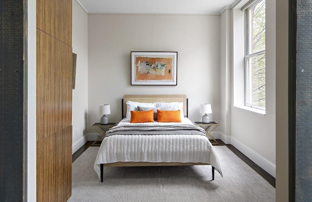 bedroom featuring wood finished floors and baseboards