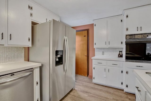 kitchen featuring stainless steel appliances, white cabinets, light hardwood / wood-style floors, and decorative backsplash