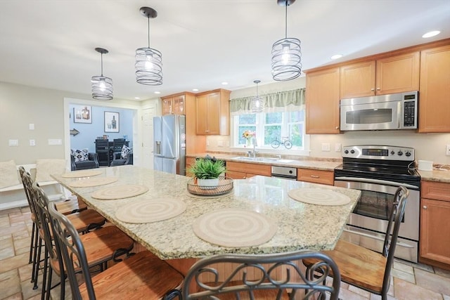 211 Hayden Rowe St, Hopkinton, MA 01748 - kitchen with appliances with stainless steel finishes, stone tile floors, recessed lighting, a kitchen bar, and light stone counters