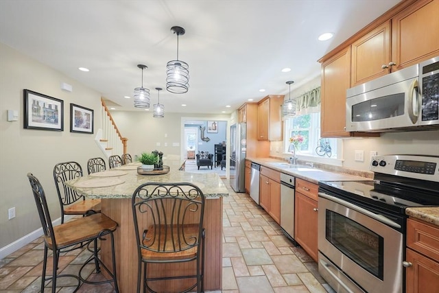211 Hayden Rowe St, Hopkinton, MA 01748 - kitchen featuring stainless steel appliances, stone tile floors, a breakfast bar, recessed lighting, and a center island