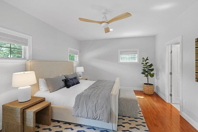 bedroom with wood finished floors, baseboards, and ceiling fan