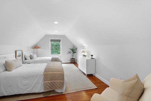 bedroom featuring wood finished floors, vaulted ceiling, and baseboards