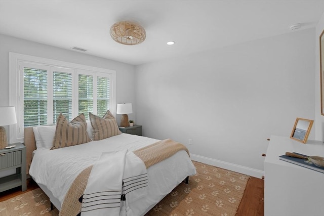 bedroom featuring wood finished floors, baseboards, and recessed lighting
