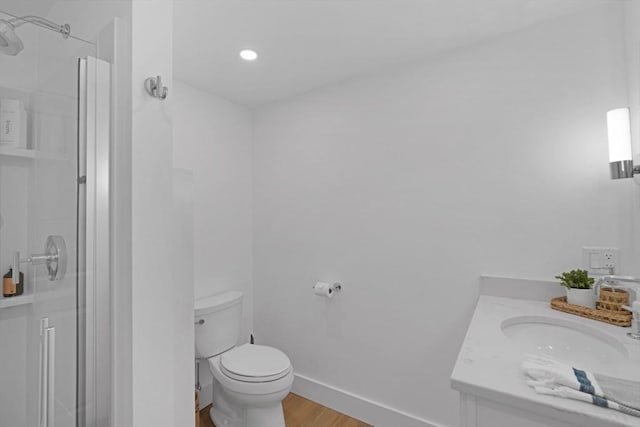full bath featuring a shower stall, toilet, wood finished floors, vanity, and recessed lighting