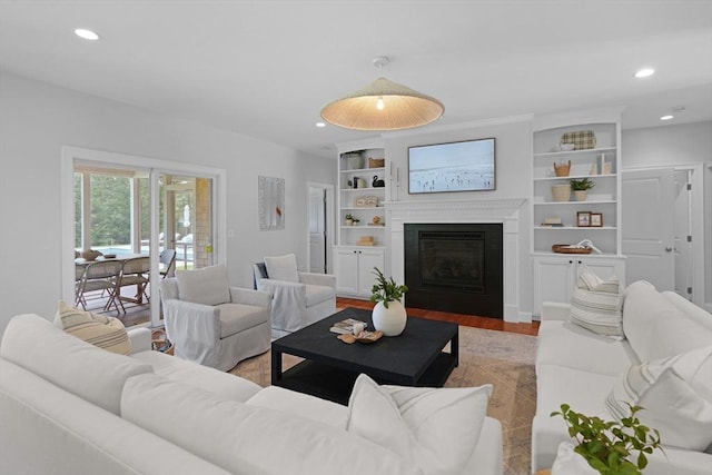 living area with wood finished floors, recessed lighting, and a glass covered fireplace