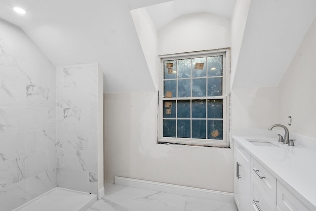 bathroom with a shower, vanity, and vaulted ceiling