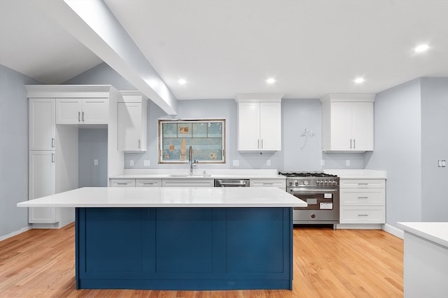 kitchen featuring a kitchen island, white cabinetry, sink, and appliances with stainless steel finishes