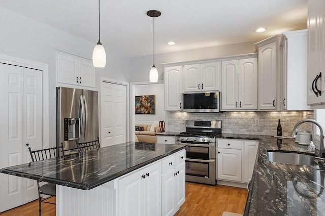 kitchen featuring stainless steel appliances, white cabinets, and a kitchen breakfast bar