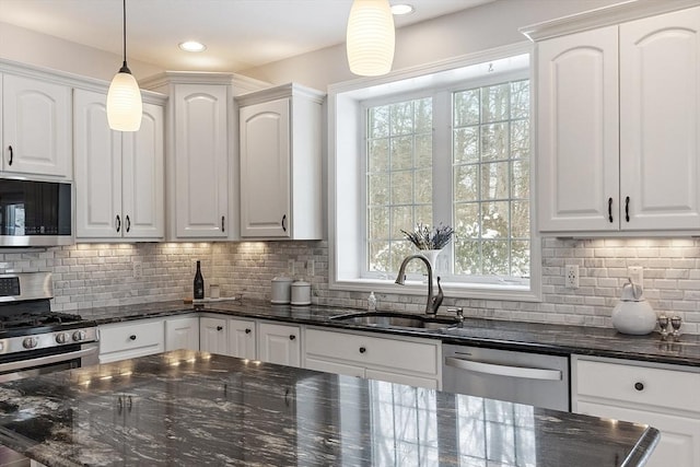 kitchen with white cabinetry, appliances with stainless steel finishes, and decorative light fixtures