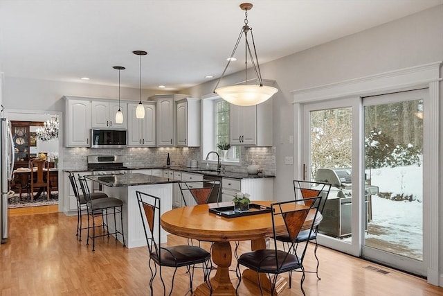 dining space with sink and light hardwood / wood-style floors