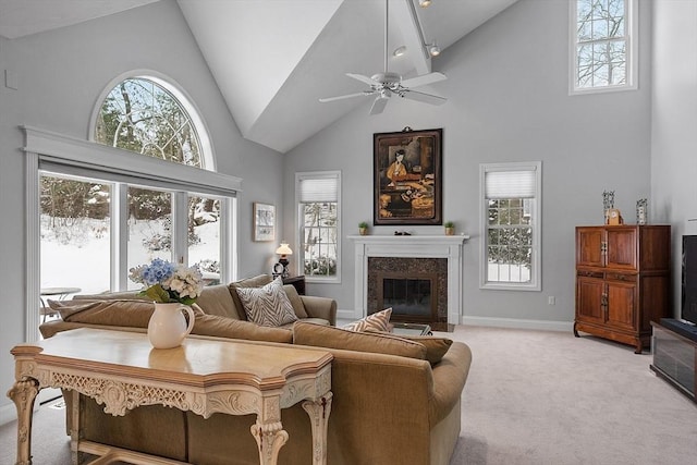 carpeted living room featuring ceiling fan, a premium fireplace, and high vaulted ceiling